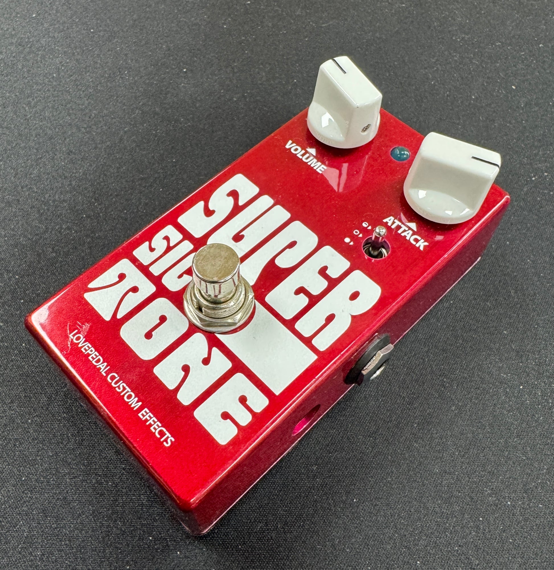 Red guitar effects pedal with white text on a gray background