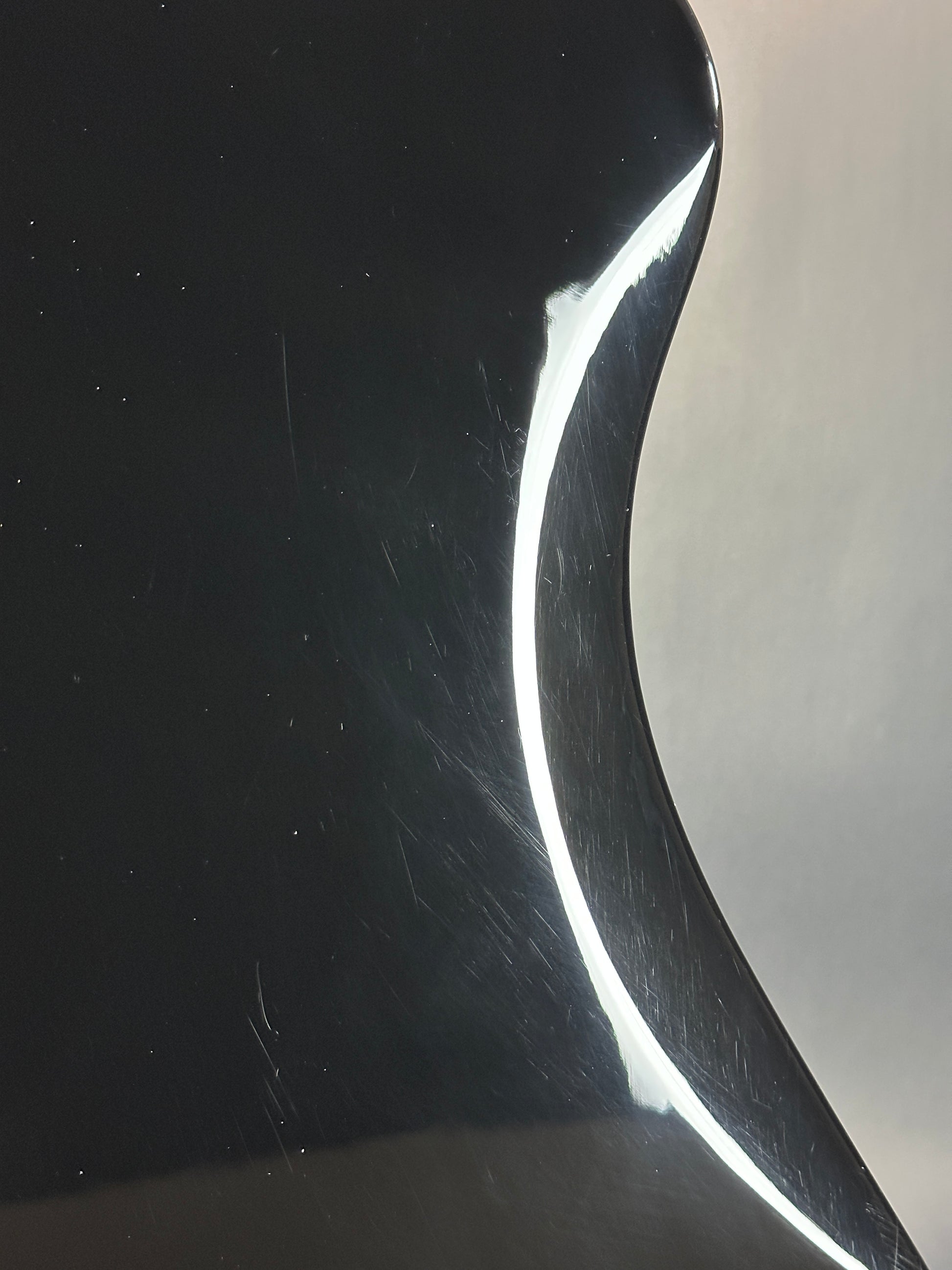 Close-up of a curved metallic surface with reflections