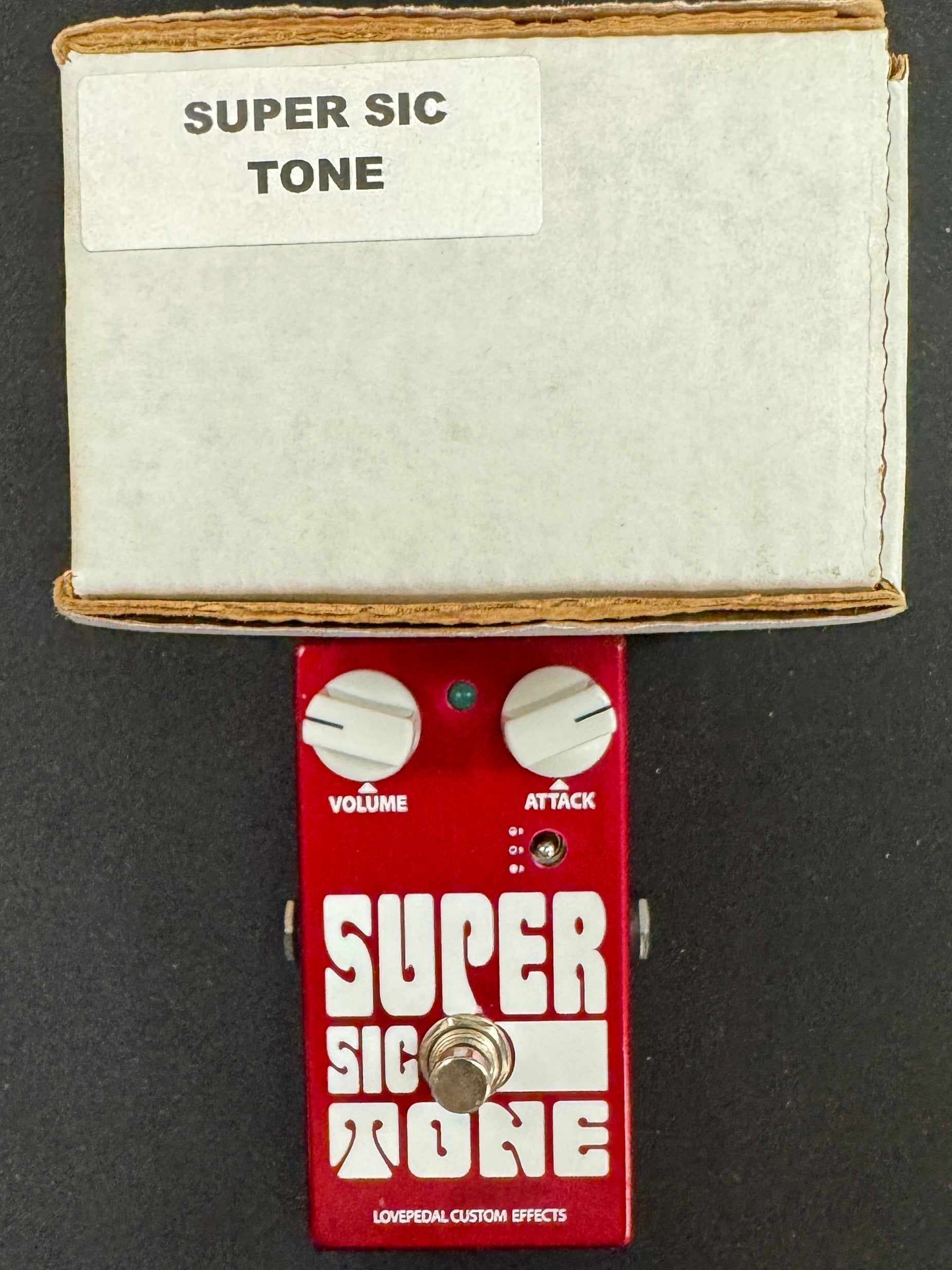 Red guitar effects pedal with 'Super Sic Tone' and 'Super Sic More' labels on a black background