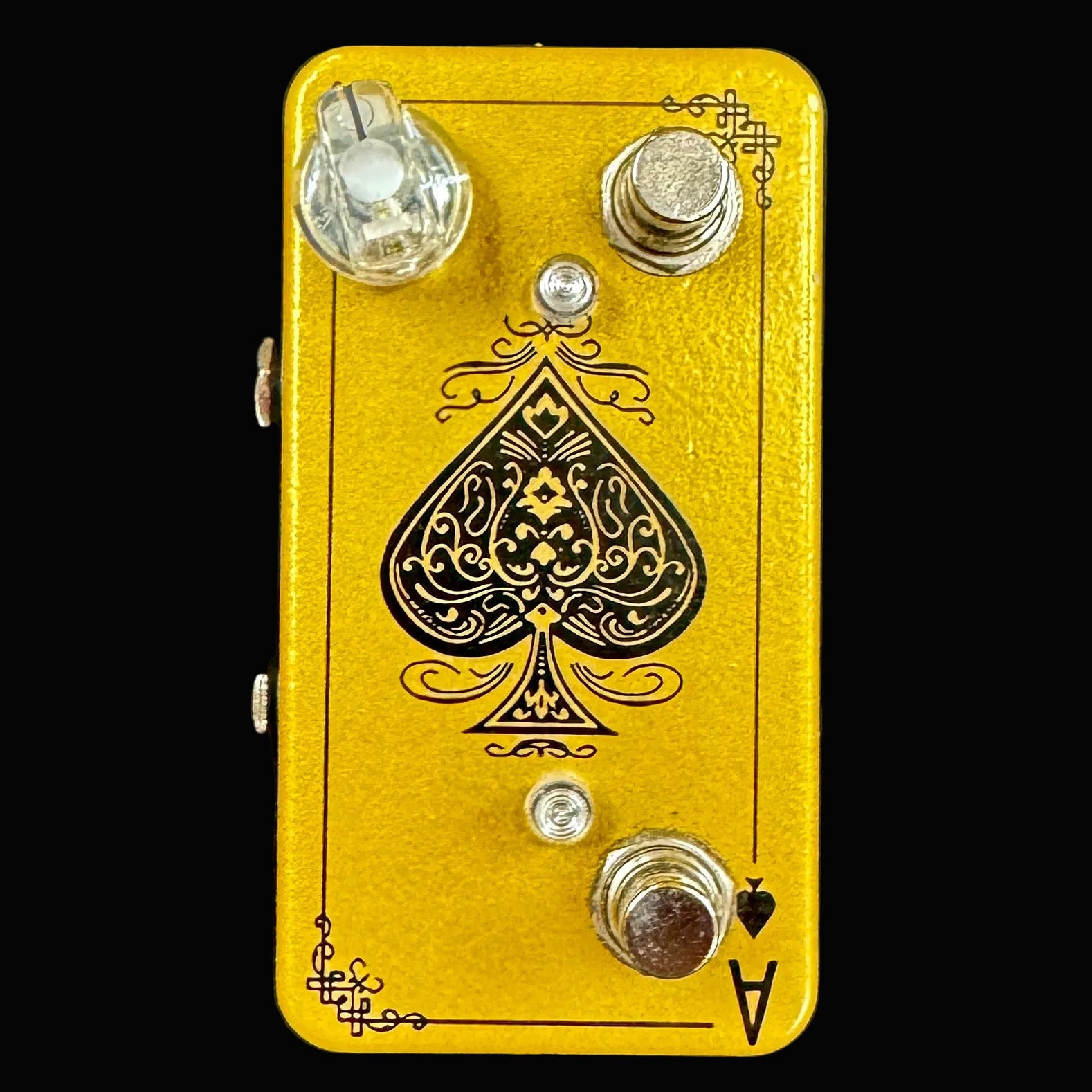 Yellow guitar effects pedal with a spade symbol on a black background