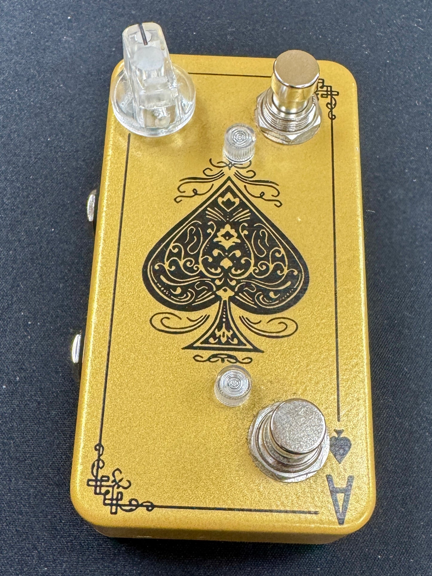 Guitar effects pedal with a spade symbol on a black background