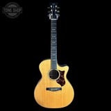 Acoustic guitar with a visible brand logo on a black background