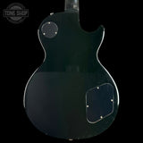 The back of a black electric guitar body, photographed against a solid black background. A circular Tone Shop watermark is visible in the top-left corner.