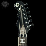 Close-up of a guitar headstock with brand logo in the corner
