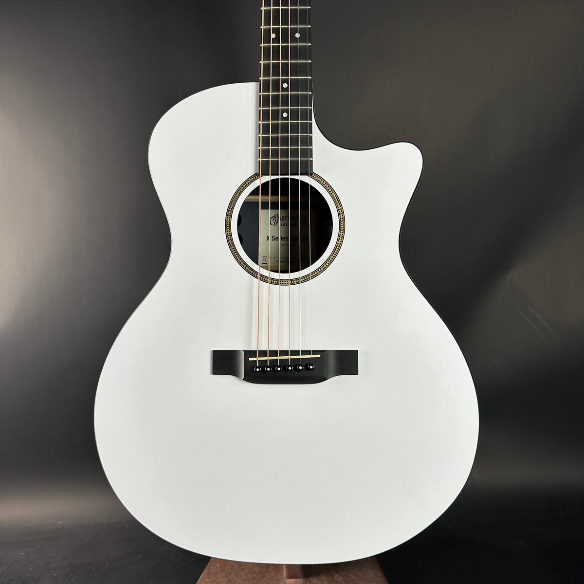 White acoustic guitar on a dark background