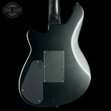 Black electric guitar on a black background with 'Tone Shop' logo.