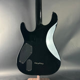 Black electric guitar on a reflective gray surface