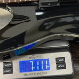 Digital kitchen scale displaying weight of a pan with a blue light indicator.