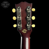 Gibson guitar headstock with tuning pegs on a black background