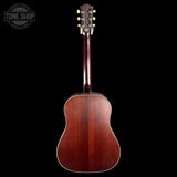 Acoustic guitar with a dark brown finish on a black background, featuring the Tone Shop logo.