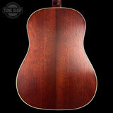 Close-up of a wooden acoustic guitar body with 'Tone Shop' logo in the corner.