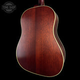 Wooden acoustic guitar body with 'Tone Shop' logo in the corner