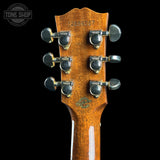 Close-up of the headstock of a Gibson ES-335 guitar, showing the six tuning pegs and the Gibson logo, on a black background.