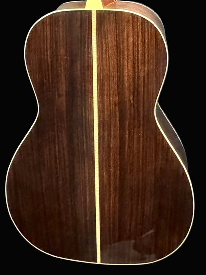 Wooden acoustic guitar body with a dark brown finish on a gray background