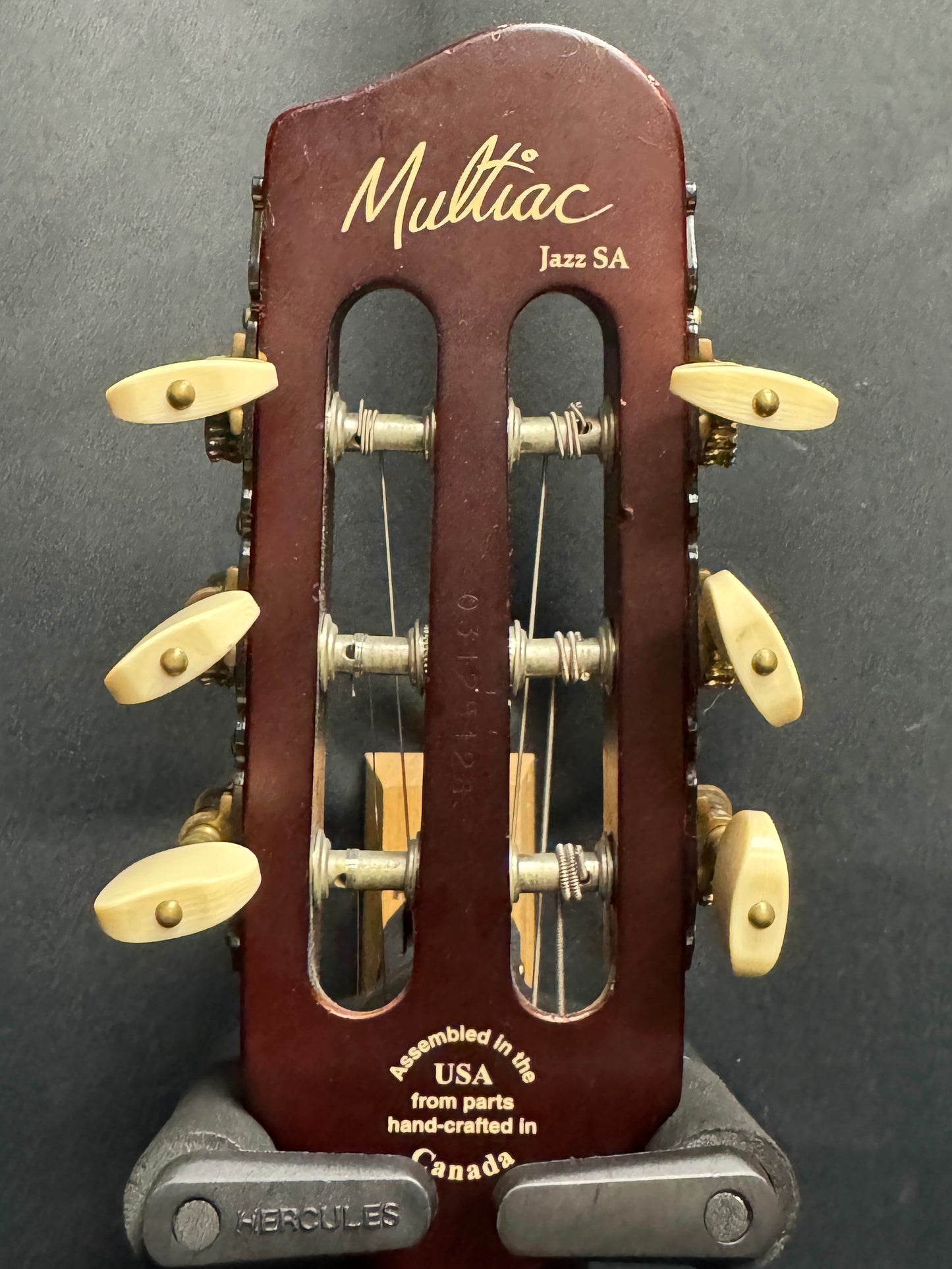 Multiaac Jazz SA guitar headstock on a gray background
