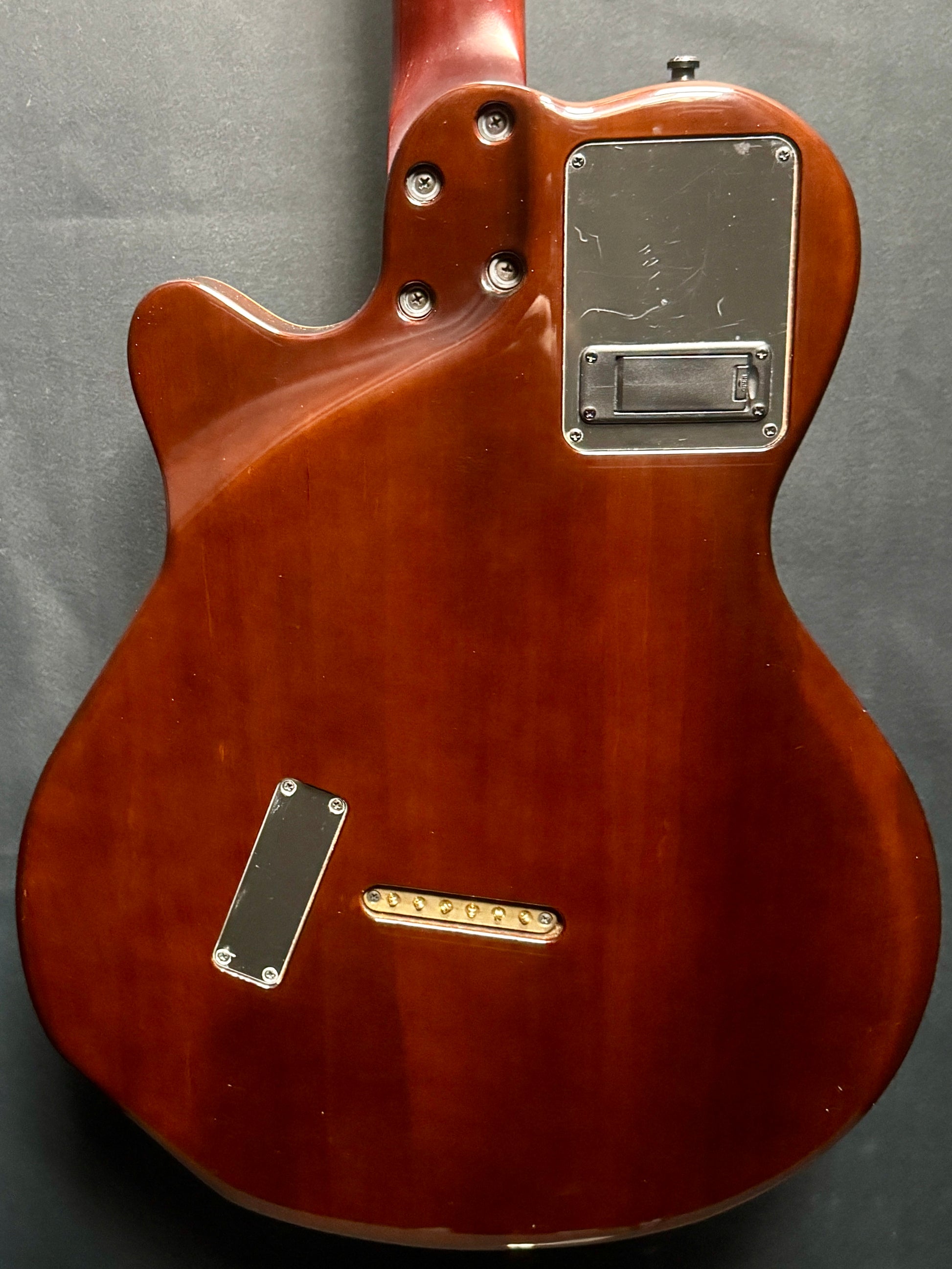 Close-up of a brown electric guitar on a gray background