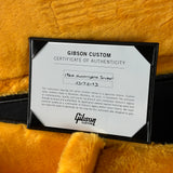Gibson Custom Certificate of Authenticity on a textured orange surface