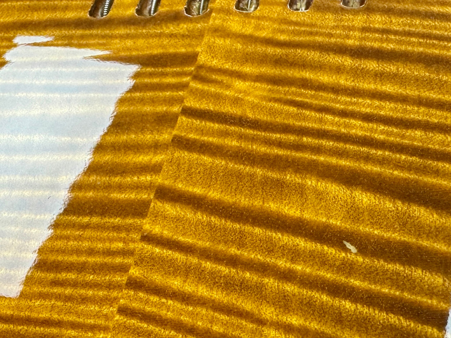 Close-up of a textured gold surface with a white stripe