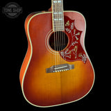Acoustic guitar with a decorative inlay on a black background, featuring the Tone Shop logo.