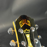 Guitar headstock with 'Guild' logo on a dark background