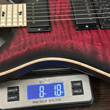 A close-up of an electric guitar body being weighed on a digital scale. The guitar has a dark red to black flame finish with a natural wood edge, and the scale displays 8.