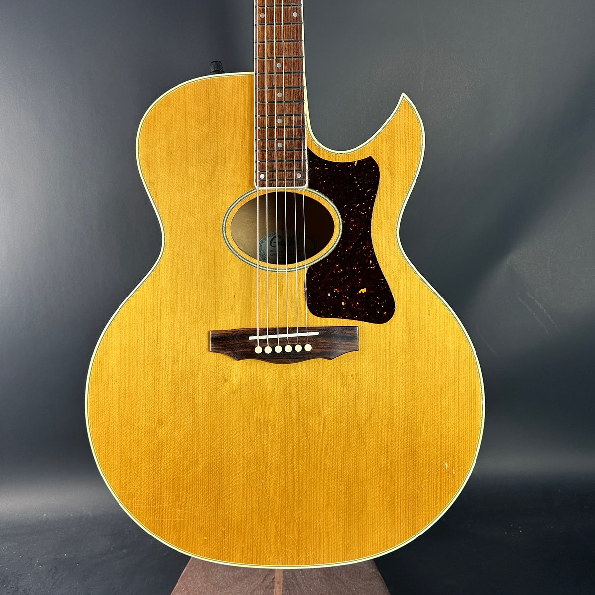 Acoustic guitar with a wooden finish on a dark background