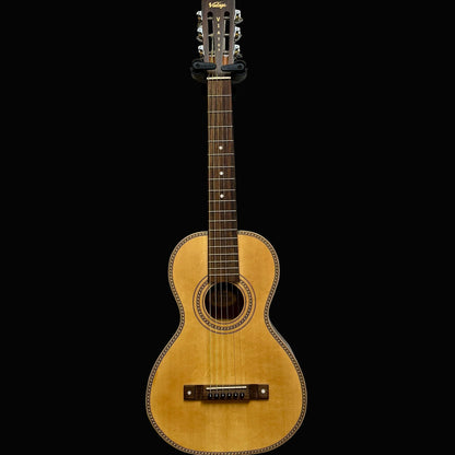 Acoustic guitar against a plain light gray wall