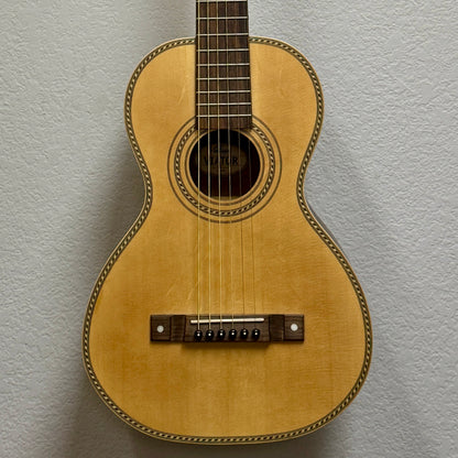 Small wooden guitar on a textured gray background