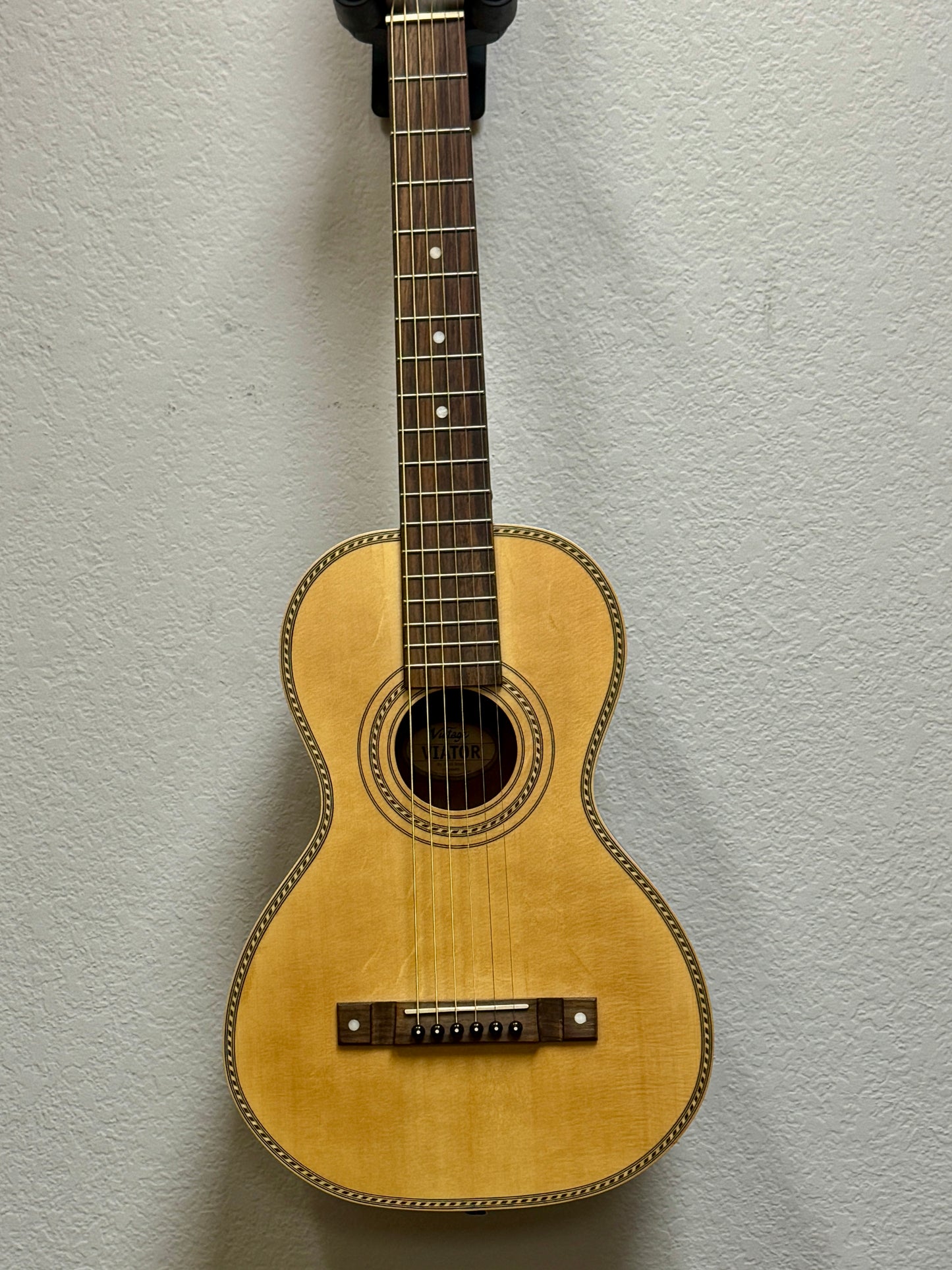 Acoustic guitar against a light gray wall