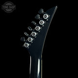 Close-up of a guitar neck with tuning pegs on a black background, featuring the Tone Shop logo.