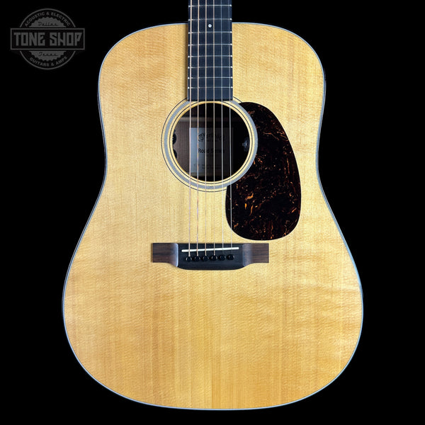 A natural wood acoustic guitar shown from the front against a solid black background, featuring a flamed maple top, dark pickguard, and black neck.