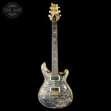 Electric guitar with a wavy wood finish on a black background, featuring the Tone Shop logo.