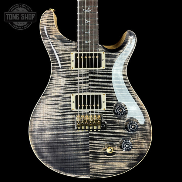 Electric guitar with a unique wood finish on a black background, featuring the Tone Shop logo.