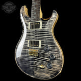 Glossy electric guitar with a black and gold design on a black background, featuring 'Tone Shop' branding.