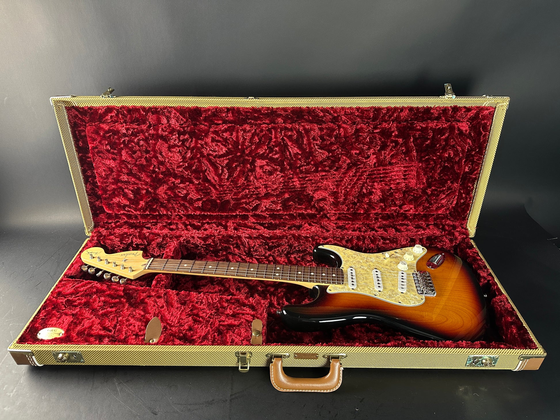 Electric guitar in a red-lined case on a gray background