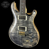 Electric guitar with a unique wood finish on a black background, featuring the Tone Shop logo.