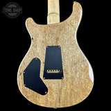 Back view of a wooden electric guitar with a black pickguard on a black background, featuring 'Tone Shop' branding.
