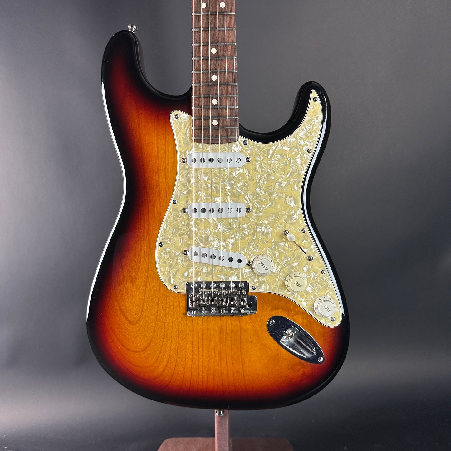 Electric guitar with sunburst finish on a gray background