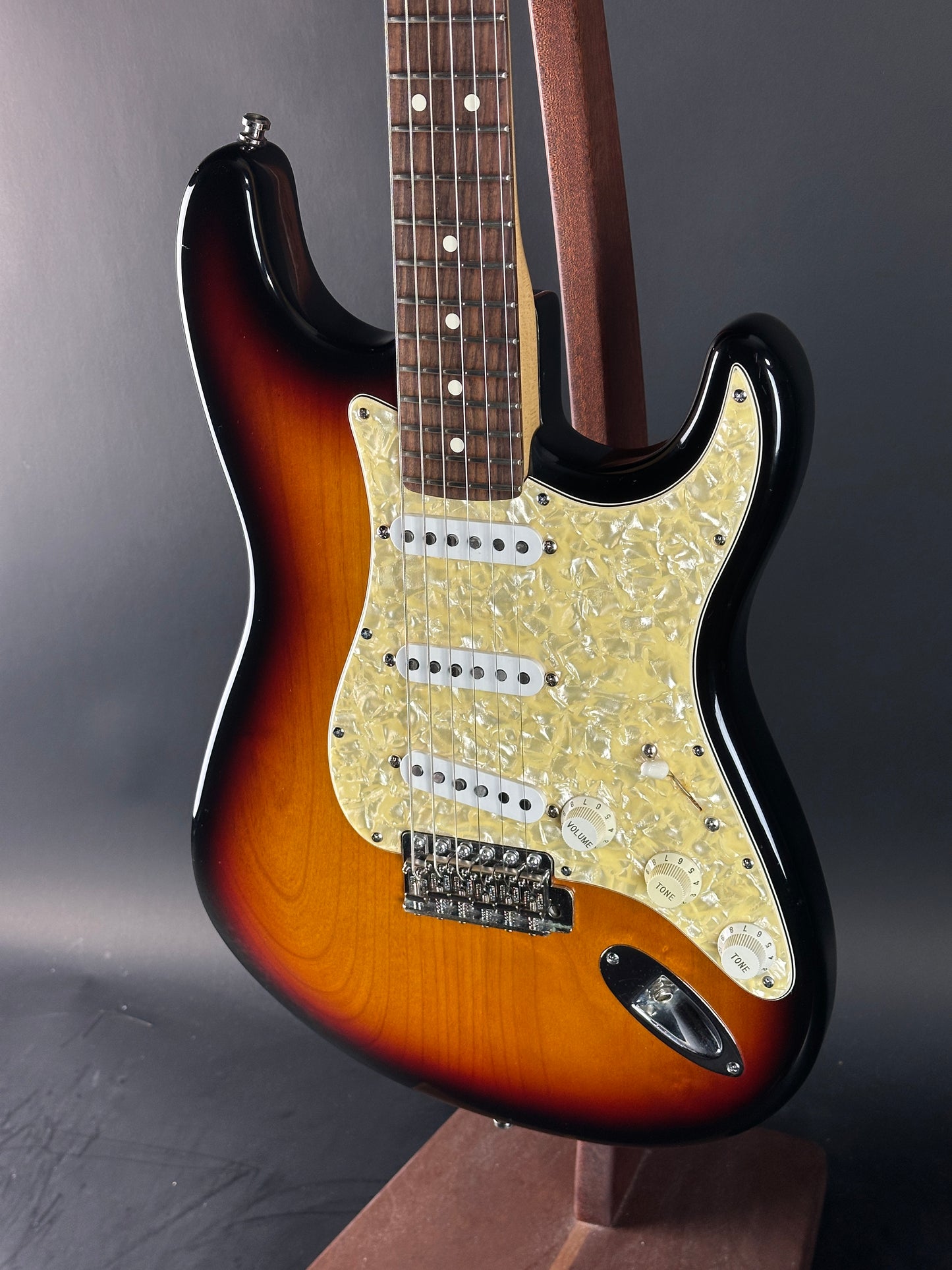 Close-up of a sunburst electric guitar on a gray background