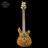 Electric guitar with a wood finish on a black background, featuring the Tone Shop logo.