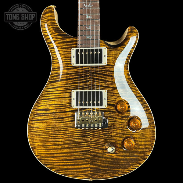 Electric guitar with a wavy wood finish on a black background, featuring the Tone Shop logo.