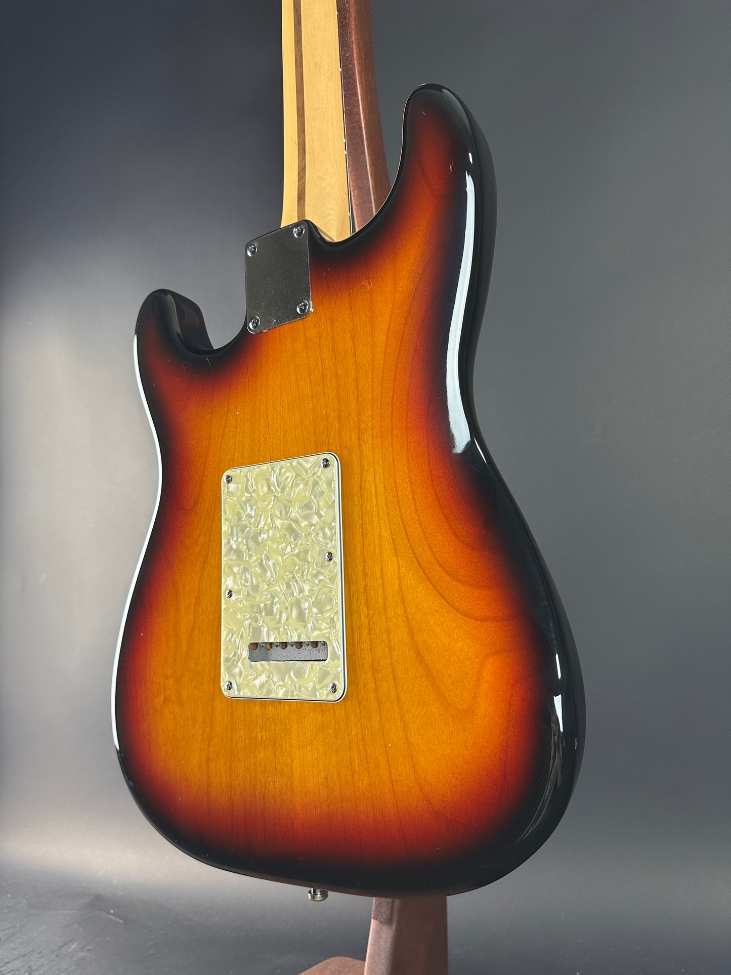Close-up of a sunburst electric guitar on a gray background