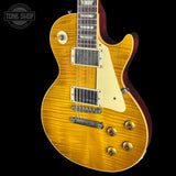A classic electric guitar with a natural flamed maple top, cream pickguard, and gold hardware, shown against a solid black background with a Tone Shop watermark in the top left corner.