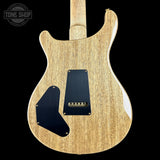 Back view of a wooden electric guitar with a black pickguard on a black background, featuring 'Tone Shop' branding.