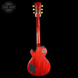 A red electric guitar shown from the back against a black background, with a Tone Shop watermark in the upper left corner.