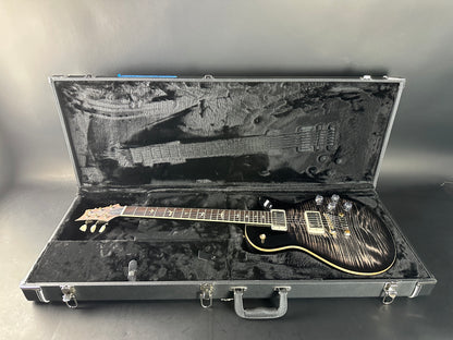 Electric guitar in an open hard-shell case on a gray background