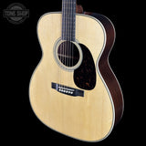 Acoustic guitar with a visible brand logo on a black background