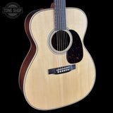 Acoustic guitar with a visible brand logo on a black background