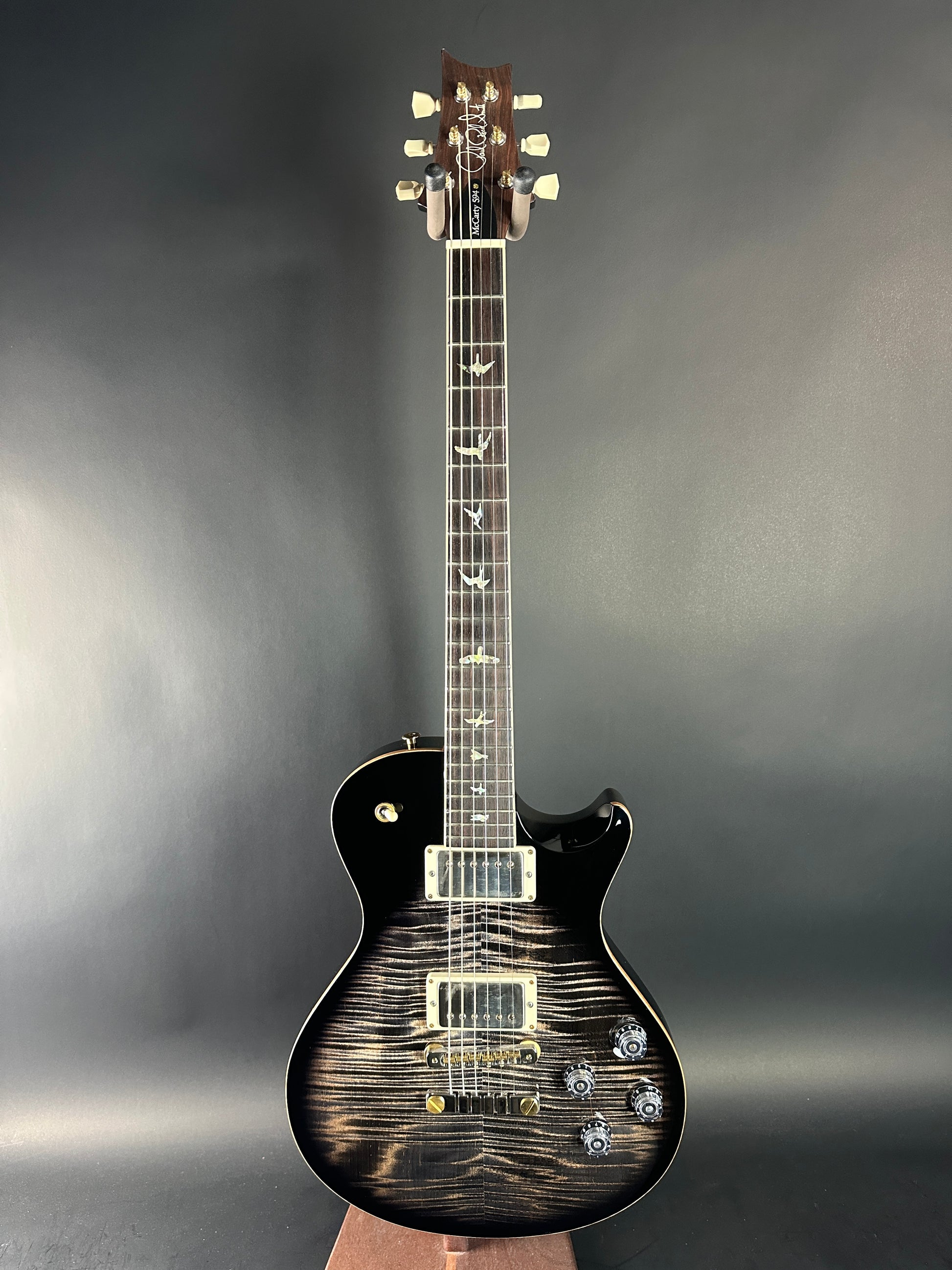 Electric guitar with a black and brown finish on a gray background