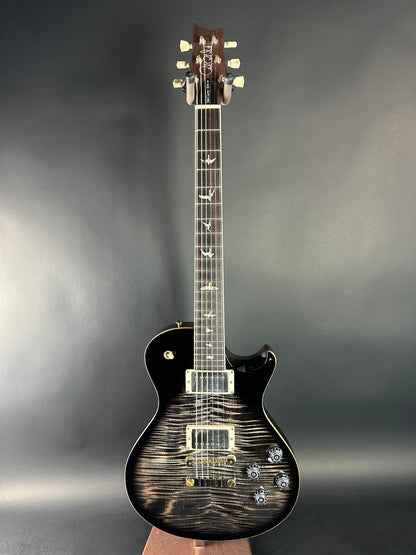 Electric guitar with a black and brown finish on a gray background